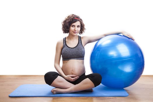 Young pregnant woman exercises with the ball.