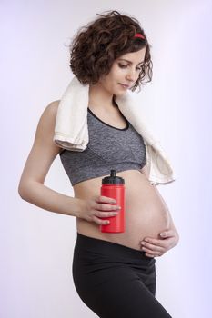 Young pregnant woman practicing fitness. Isolated on white background