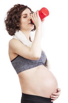 Young pregnant woman practicing fitness. Isolated on white background