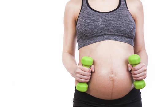 Young pregnant woman practicing fitness. Isolated on white background