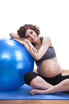 Young pregnant woman exercises with the ball.