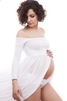 Pregnant woman in white dress on white background.