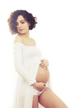 Pregnant woman in white dress on white background.