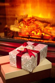 Christmas gift boxes with red ribbon in the interior with a fireplace