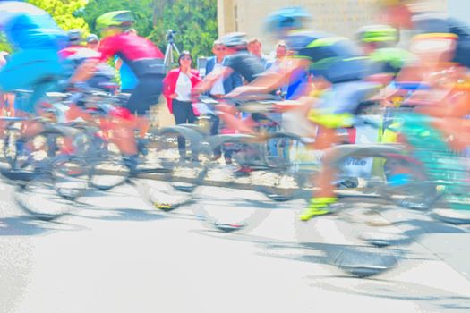 Abstract arty background : motion blur of bicycle racers competing on city streets. Tour of cycling. Blurry background sport with cyclists.