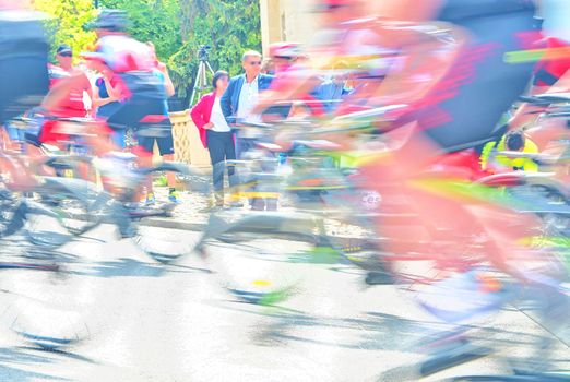 Abstract arty background : motion blur of bicycle racers competing on city streets. Tour of cycling. Blurry background sport with cyclists.