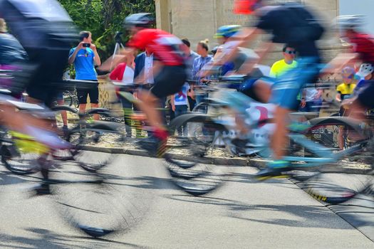 Abstract arty background : motion blur of bicycle racers competing on city streets. Tour of cycling. Blurry background sport with cyclists.