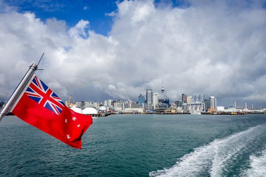Auckland view from the sea and New Zealand red civil flag