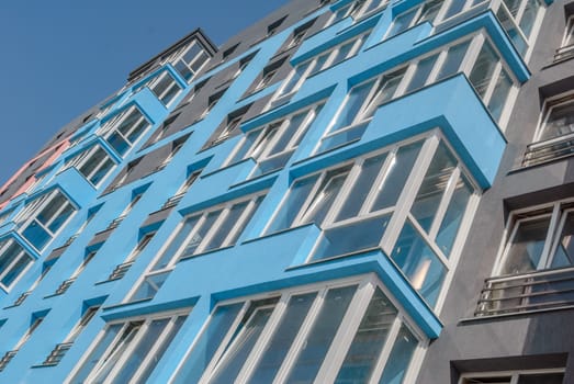 kind of a new multistorey brick residential building with balconies on a sunny day