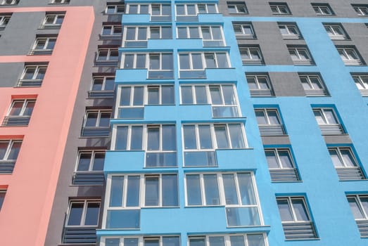 kind of a new multistorey brick residential building with balconies on a sunny day