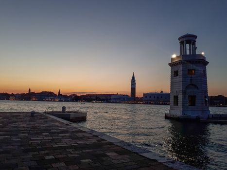 sunset in venice with a lighthouse on