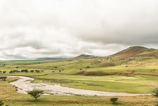 The Tugela River with a township in the back. The river forms the border of the Maloti Drakensberg Park at this point
