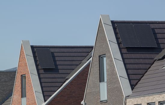 Solar panels on the roof of a house against a clear blue sky