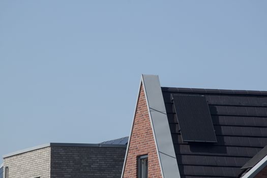 Solar panels on the roof of a house against a clear blue sky