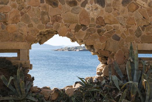 glimpse through a hole in a wall on the blue sea around maddalena island