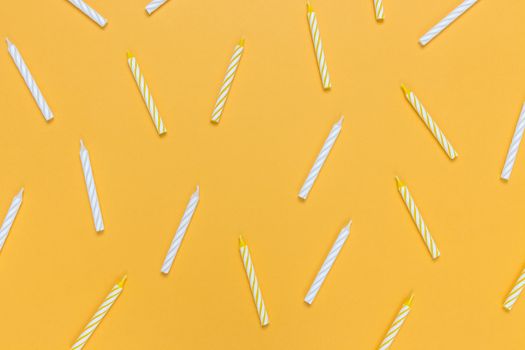 Birthday candles on bright yellow background. Flat lay composition.