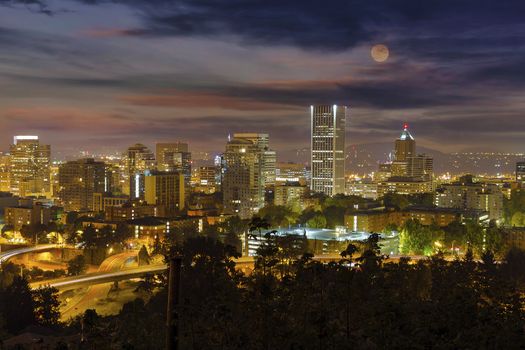 Full moon rising over Portland Oregon downtown cityscape at night
