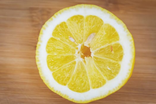 Half of a lemon with a bone on a light wooden board