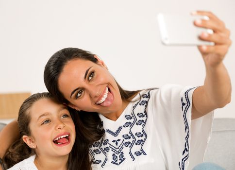 Beautiful Mom and Daughter at home making a selfie