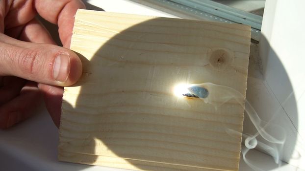 burning on the wood pattern . with the help of magnifying glass burns on a wooden board . sunbeam tree burns. draws with the help of the sun's rays.