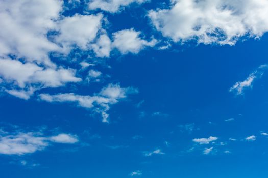 Deep blue bright sky with clouds background