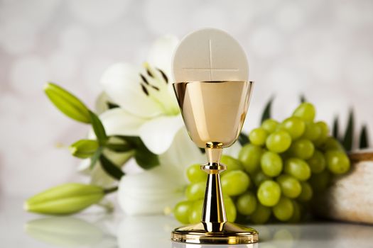 Holy communion a golden chalice with grapes and bread wafers