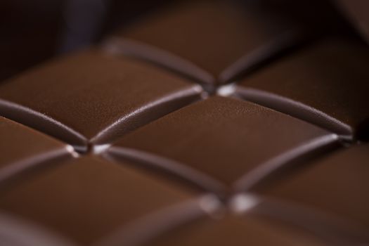 Milk and dark chocolate on a wooden table