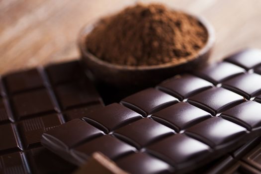 Milk and dark chocolate on a wooden table