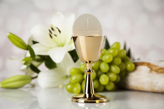 Holy communion a golden chalice with grapes and bread wafers