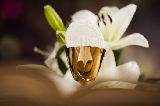 Holy communion a golden chalice with grapes and bread wafers