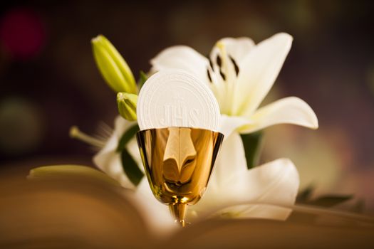 Holy communion a golden chalice with grapes and bread wafers