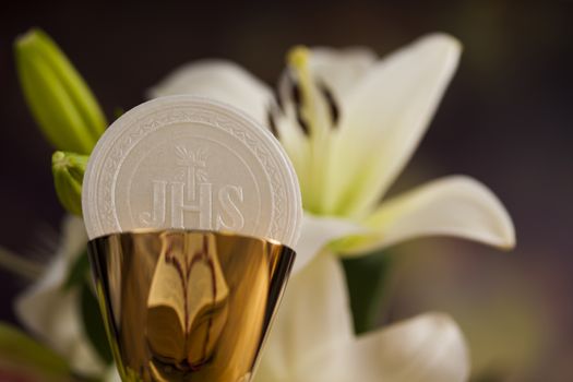 Holy communion a golden chalice with grapes and bread wafers