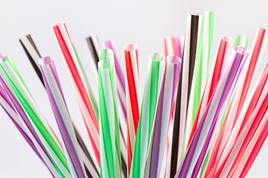 Colorful cocktail tubes in a glass cup