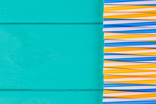 Drinking straws for party on blue pastel background with copy space. Top view