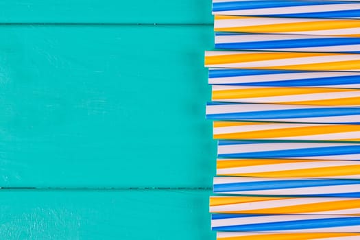 Drinking straws for party on blue pastel background with copy space. Top view