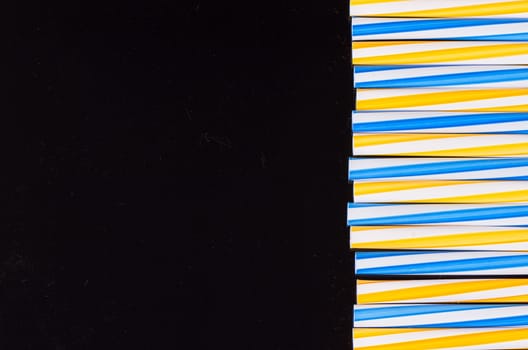 cocktail colorful plastic tube on a black background