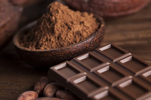 Aromatic cocoa and chocolate on wooden background