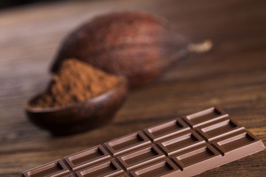 Aromatic cocoa and chocolate on wooden background