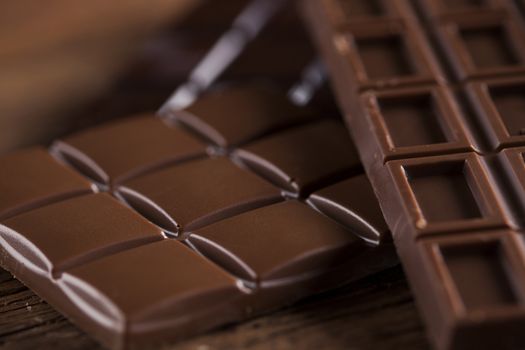 Milk and dark chocolate on a wooden table