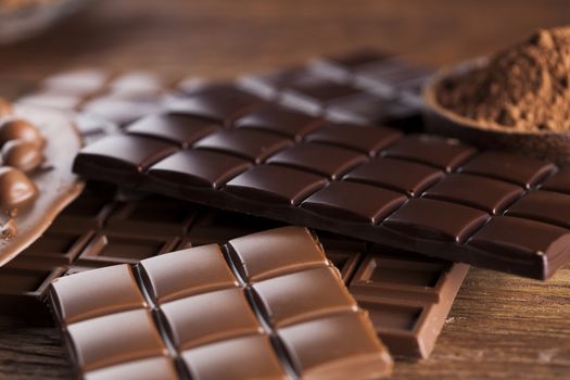 Aromatic cocoa and chocolate on wooden background