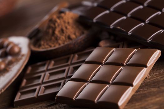 Aromatic cocoa and chocolate on wooden background