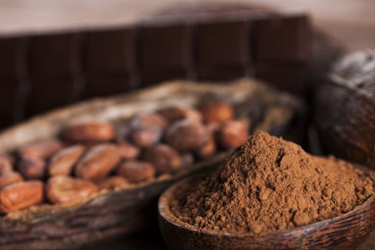 Aromatic cocoa and chocolate on wooden background