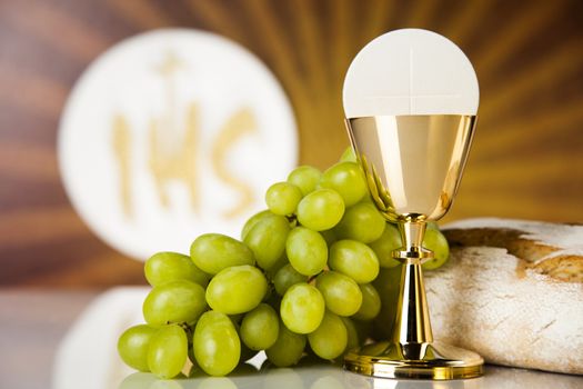 Holy communion a golden chalice with grapes and bread wafers