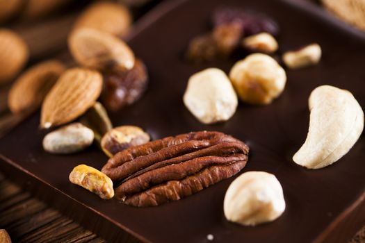 Dark homemade chocolate bars and cocoa pod on wooden