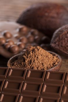 Aromatic cocoa and chocolate on wooden background