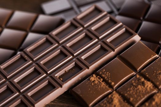 Milk and dark chocolate on a wooden table