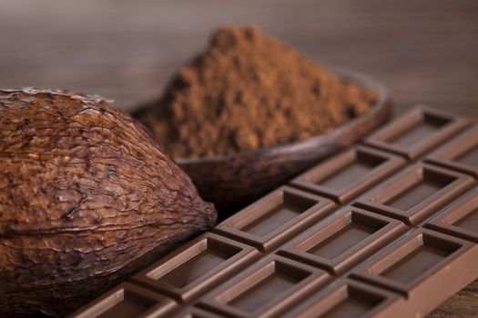 Aromatic cocoa and chocolate on wooden background