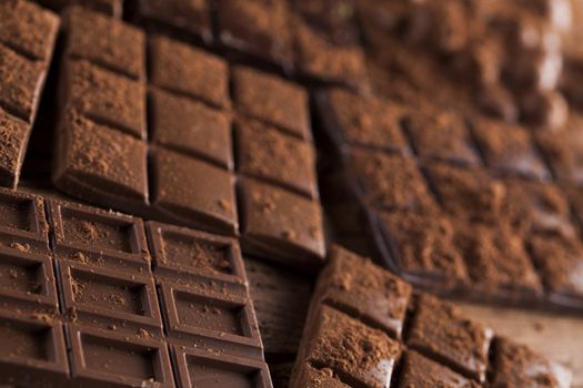 Aromatic cocoa and chocolate on wooden background