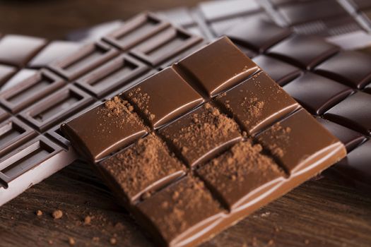 Milk and dark chocolate on a wooden table