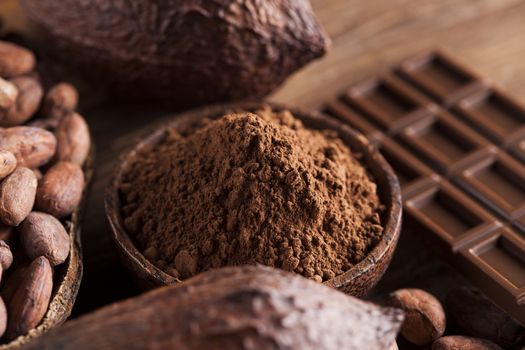 Aromatic cocoa and chocolate on wooden background